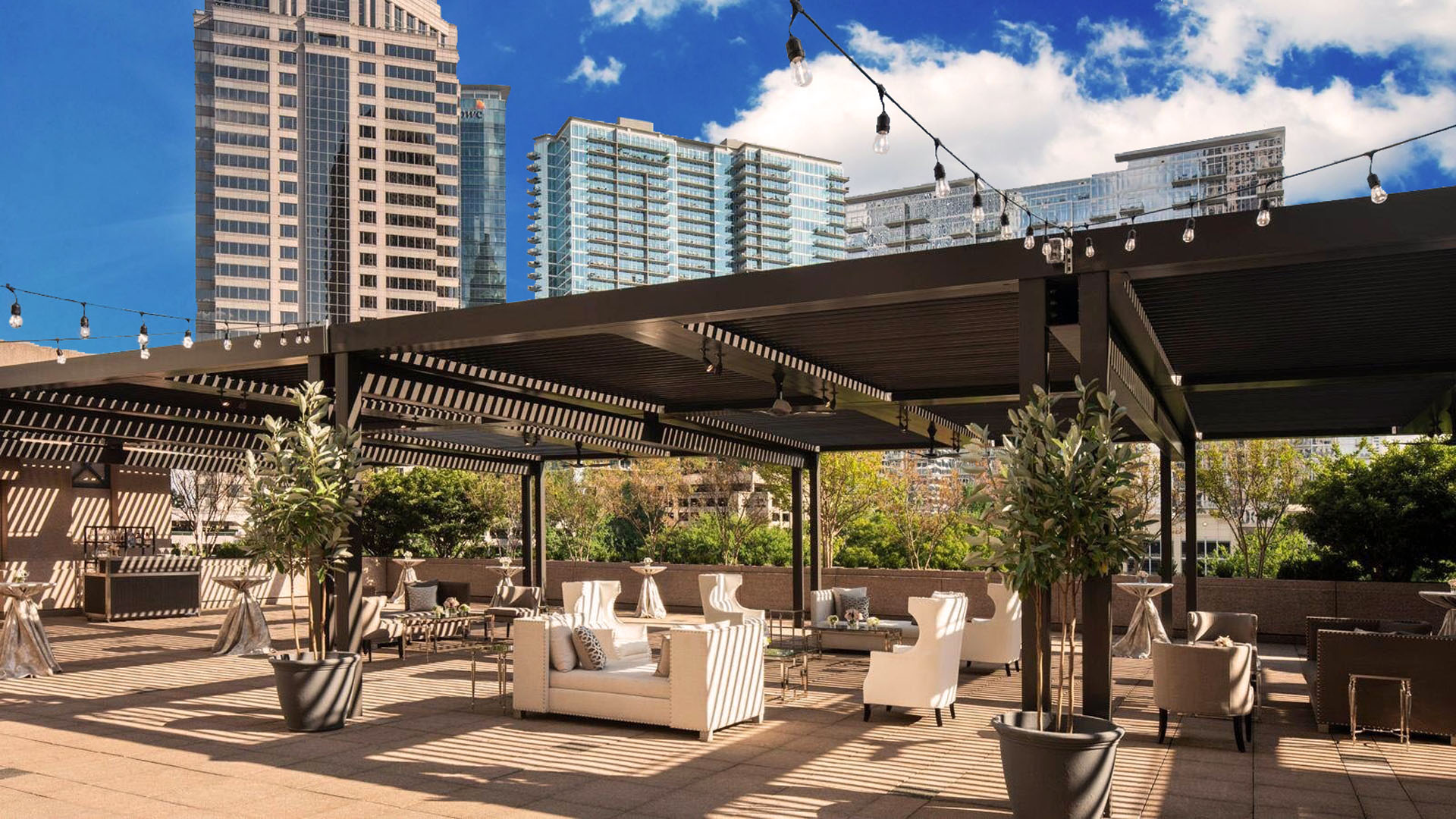 A luxurious hotel patio covered by a row of motorized pergolas.