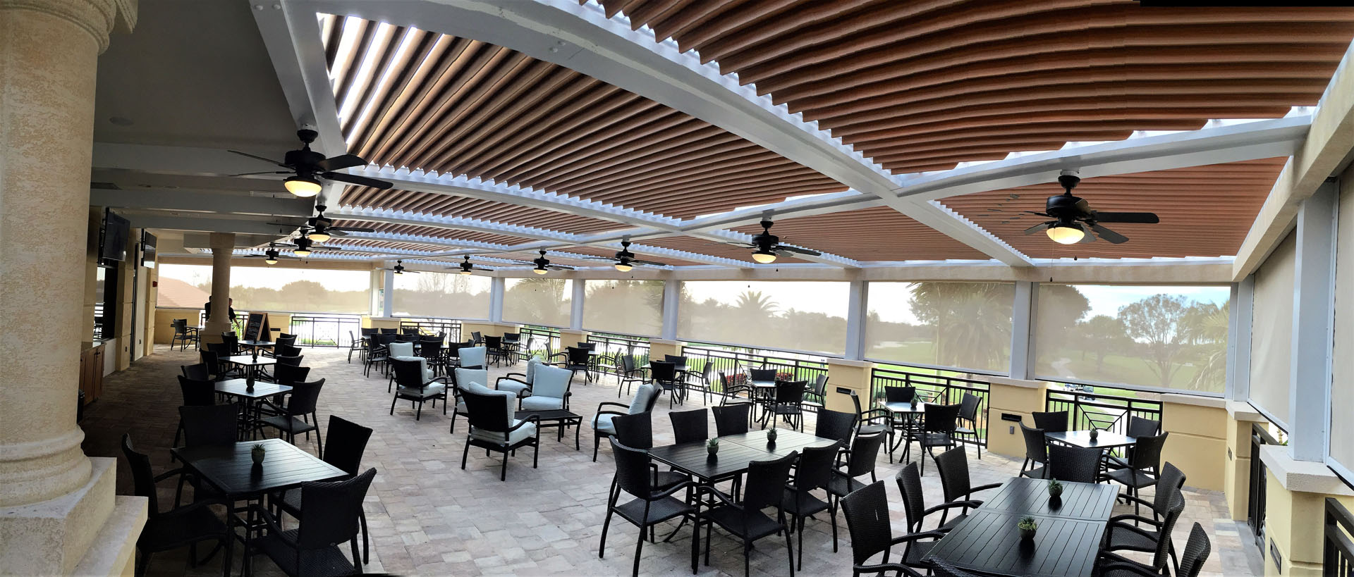 The outdoor area of a restaurant covered by a StruXure pergola that has motorized screens.