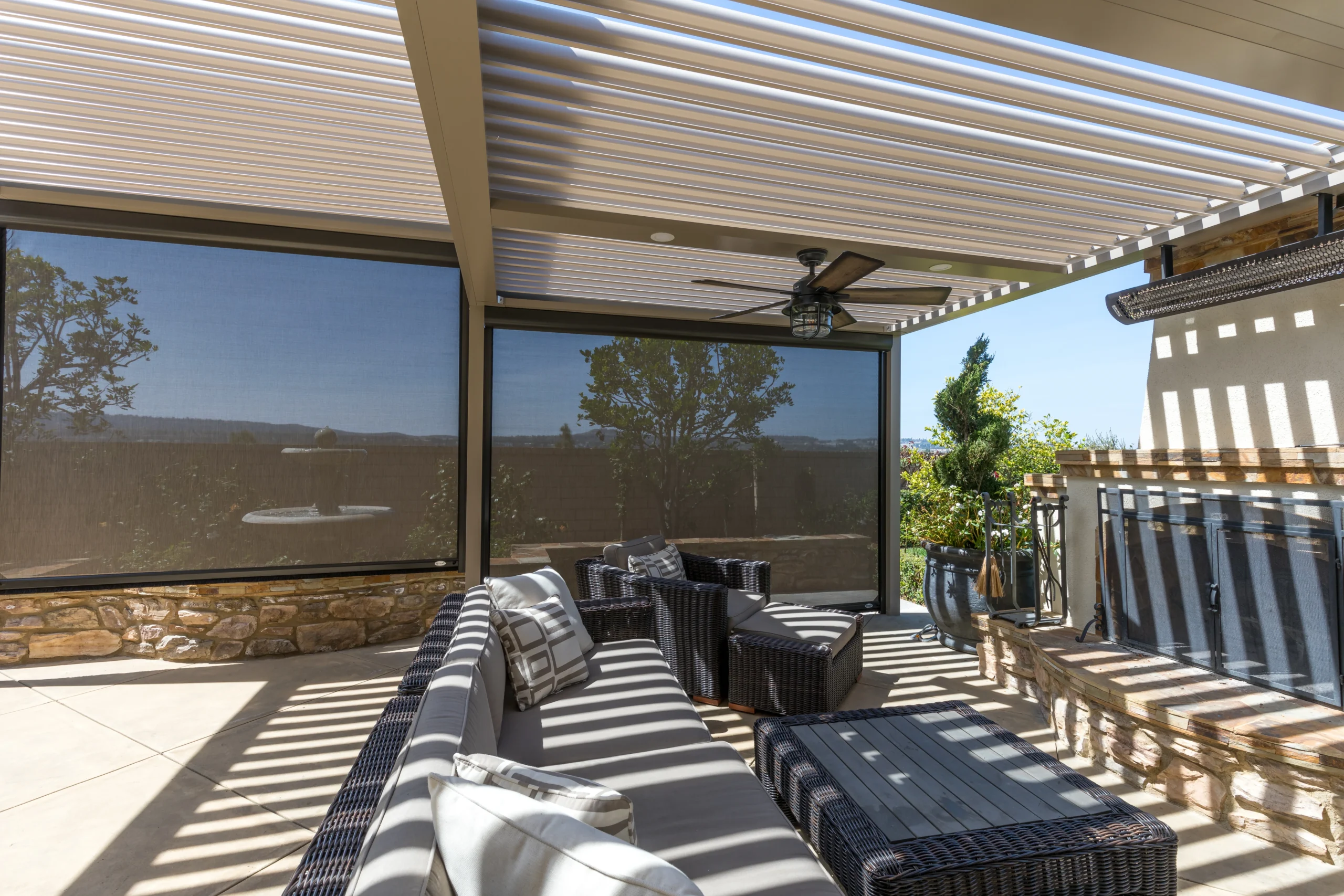 Looking up at a louvered pergola roof with motorized screen system installed in South Florida