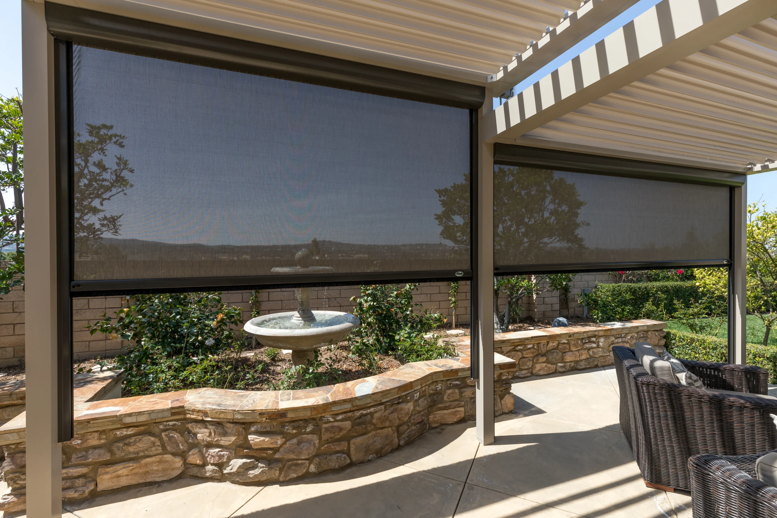 Motorized retractable screen system fully deployed on a StruXure louvered pergola patio in South Florida