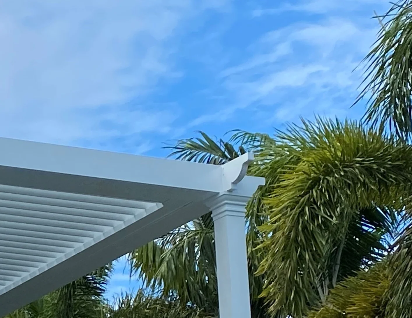 Aluminum pergola post base plate and cap detail on a South Florida patio