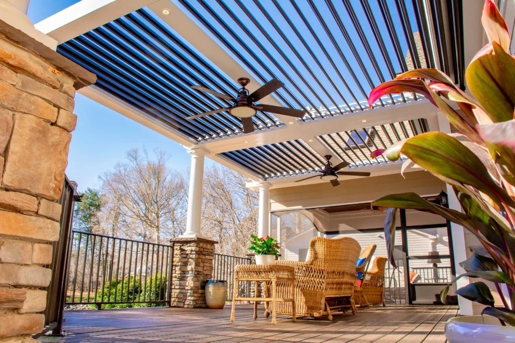Dark StruXure louvered pergola with integrated ceiling fan over a raised deck patio in Wellington FL