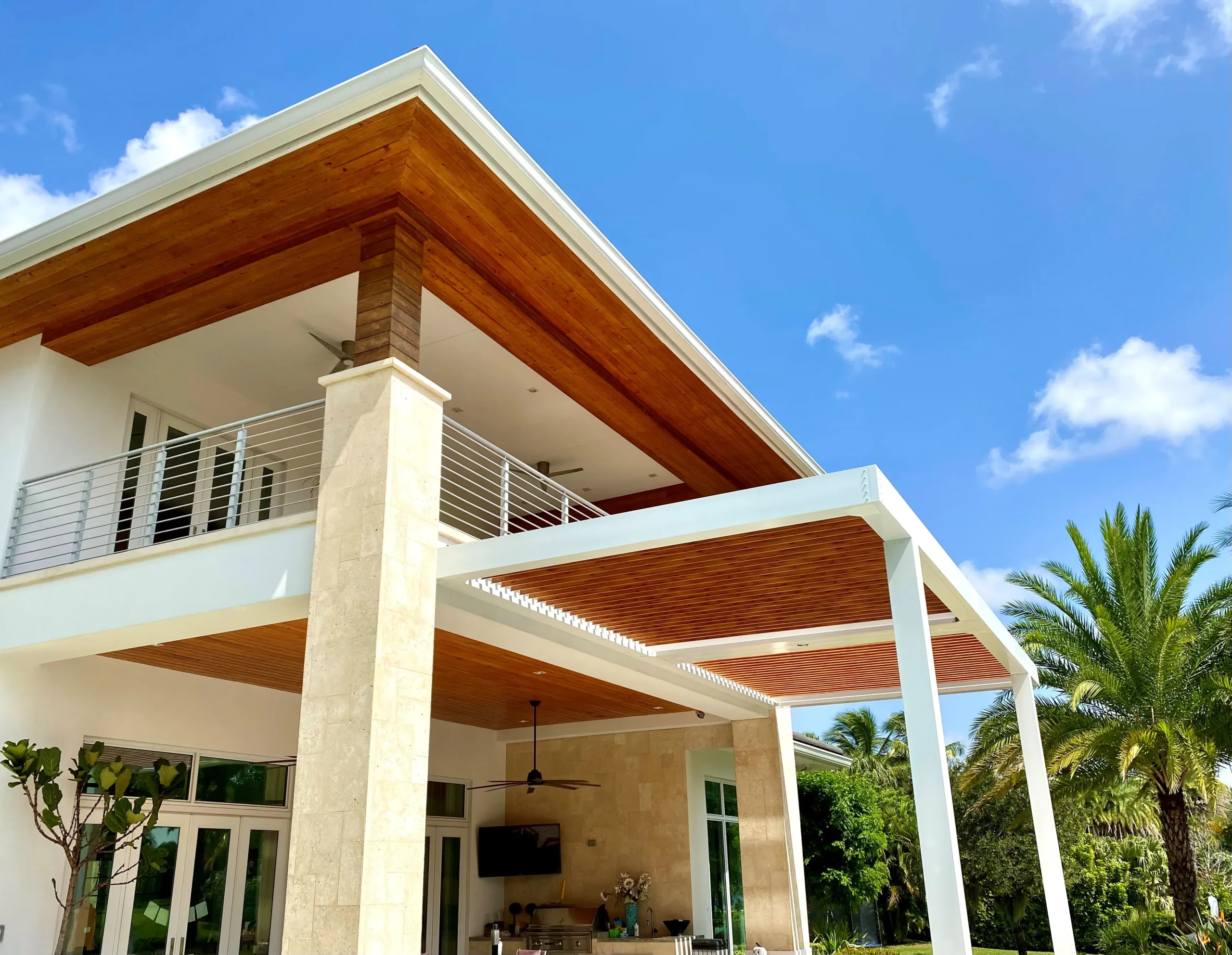Wood-grain finished aluminum louvers on a Delray Beach pergola in full afternoon sun