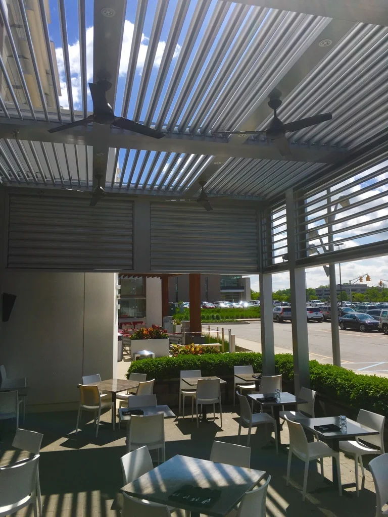 Employee break area shade over a paved seating area beside a Florida commercial parking lot