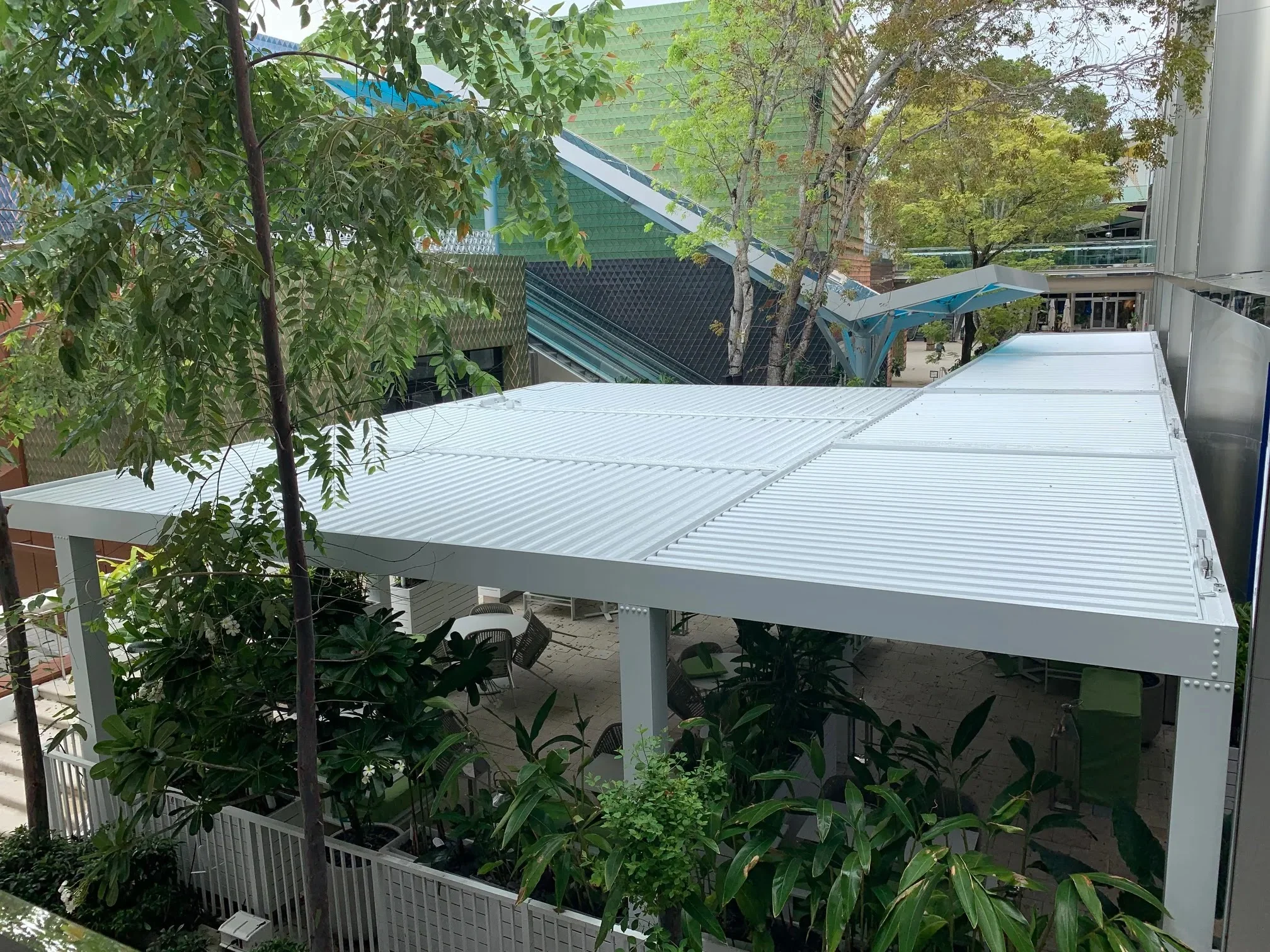 Overhead view of louvered aluminum pergolas in North Miami style over a shaded outdoor terrace