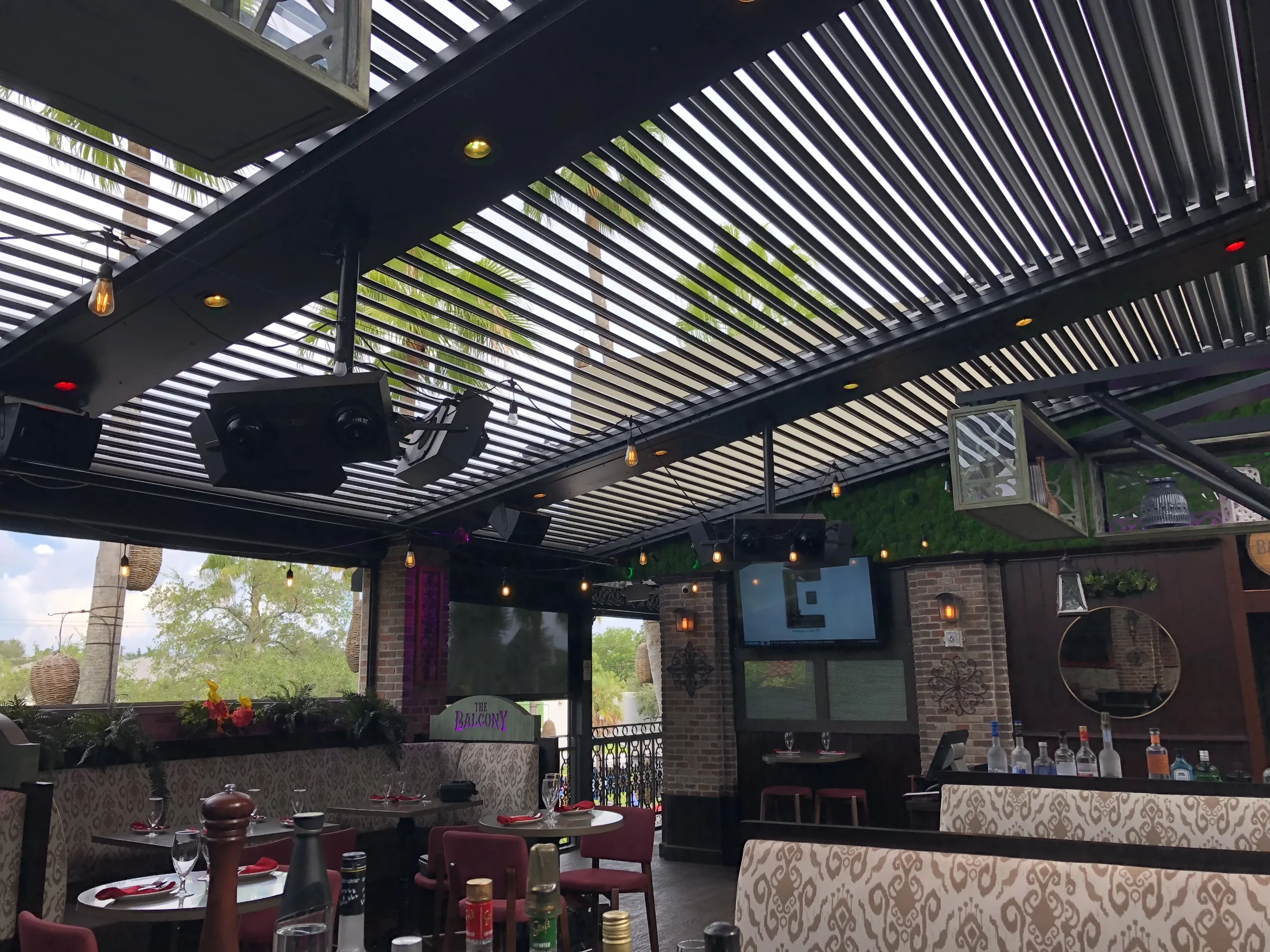 Pergola condensation check: louvers tilted open over a Las Olas patio so air moves across the underside