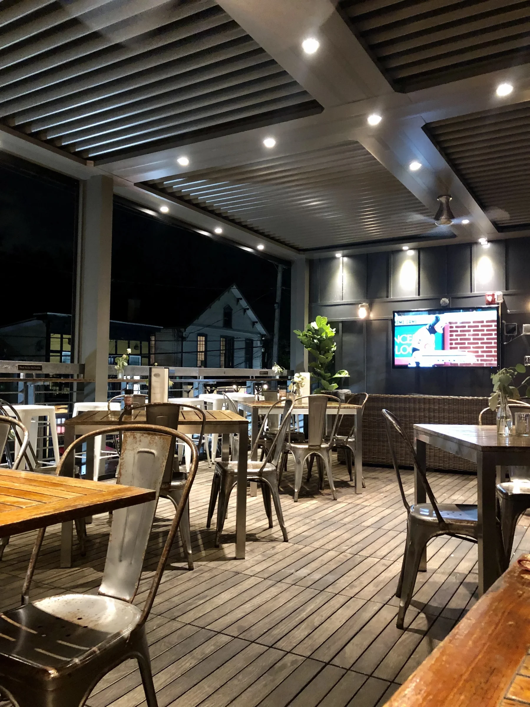 Rooftop aluminum louvered structure over an outdoor lounge and seating area