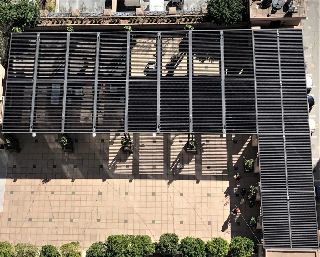 Aerial view of multiple black StruXure louvered pergola panels covering a commercial rooftop patio