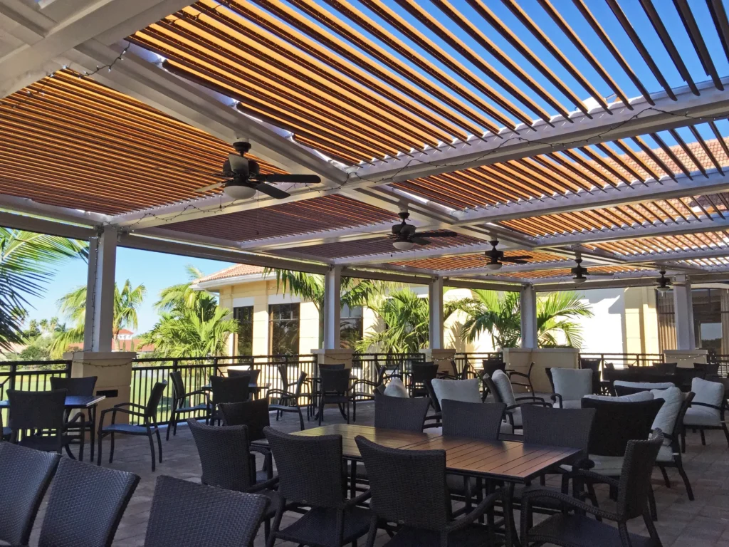 Equestrian pergola style covered terrace with wood-grain louvers overlooking a Palm Beach County green space