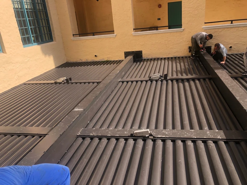 Installers fitting a louvered aluminium roof deck on a Florida commercial building