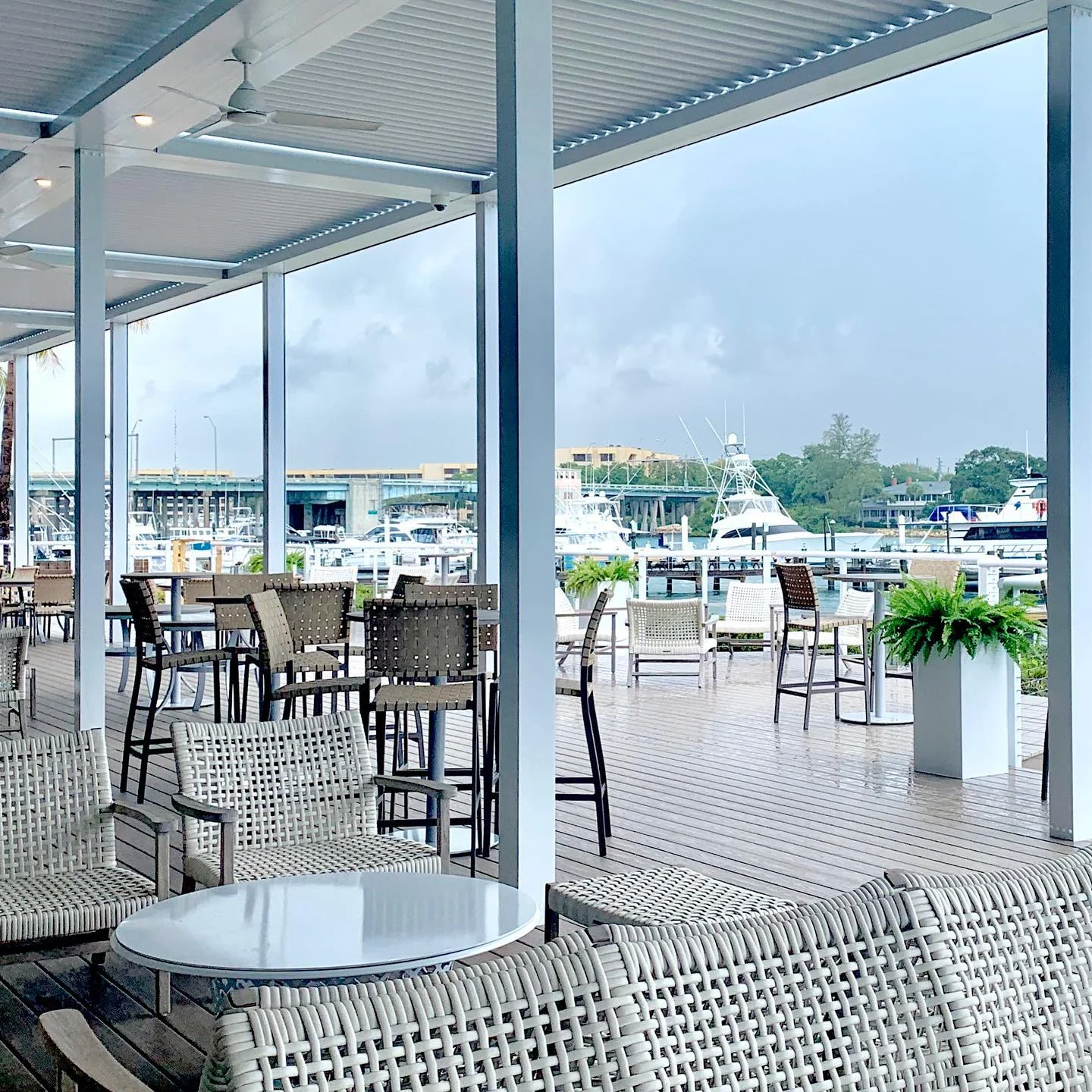 Waterfront club dining room and covered terrace overlooking a marina full of boats