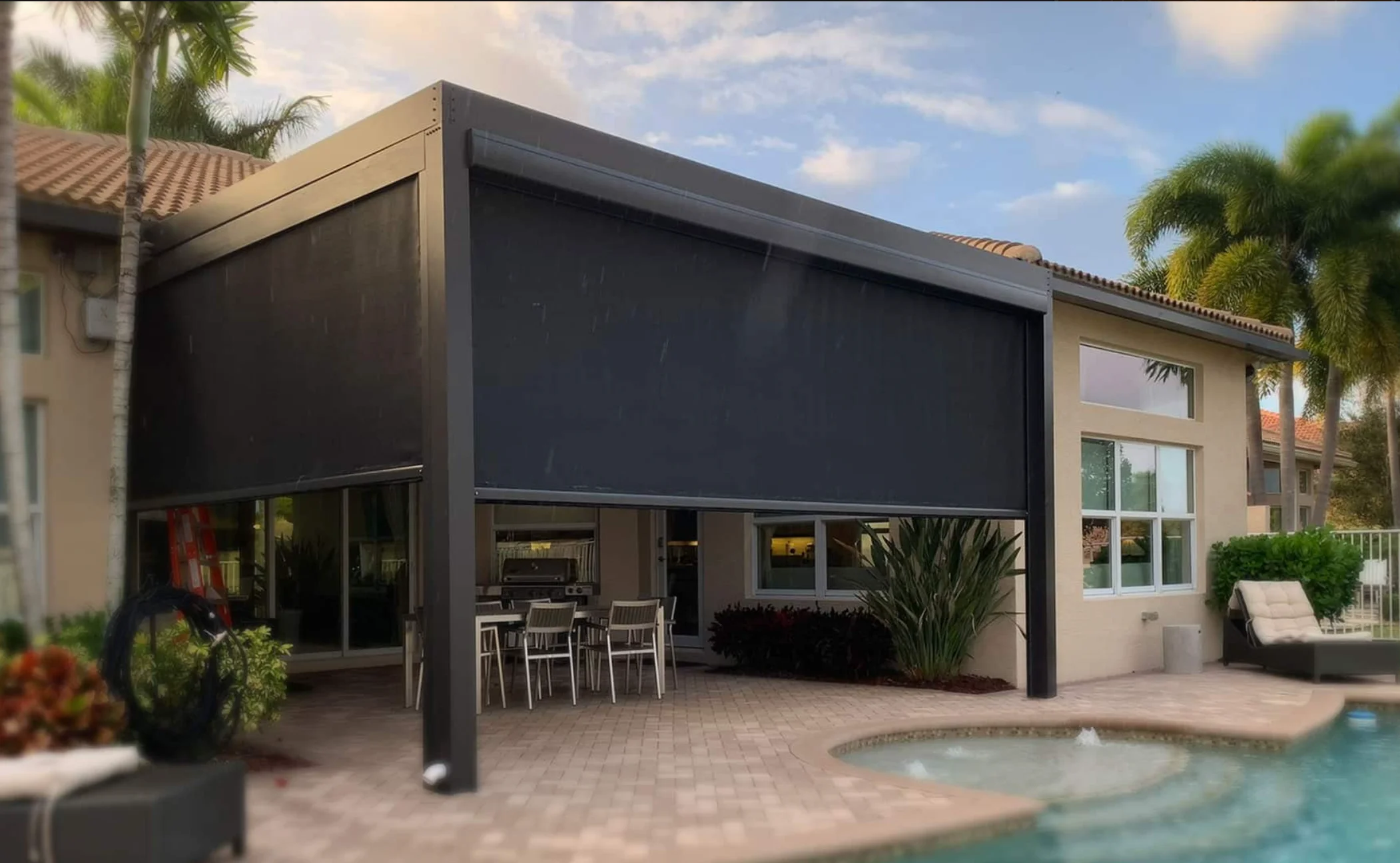 StruXure louvered pergola with motorized screens deployed around a swimming pool patio in South Florida
