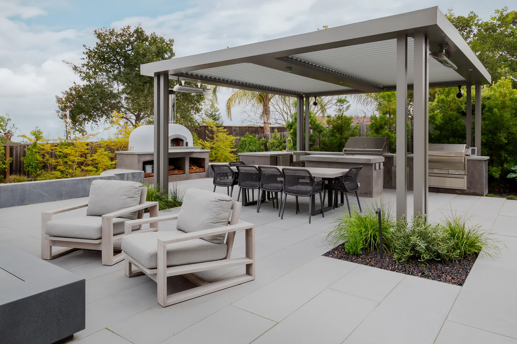 White aluminum pergola over a paved patio with lounge seating in South Florida