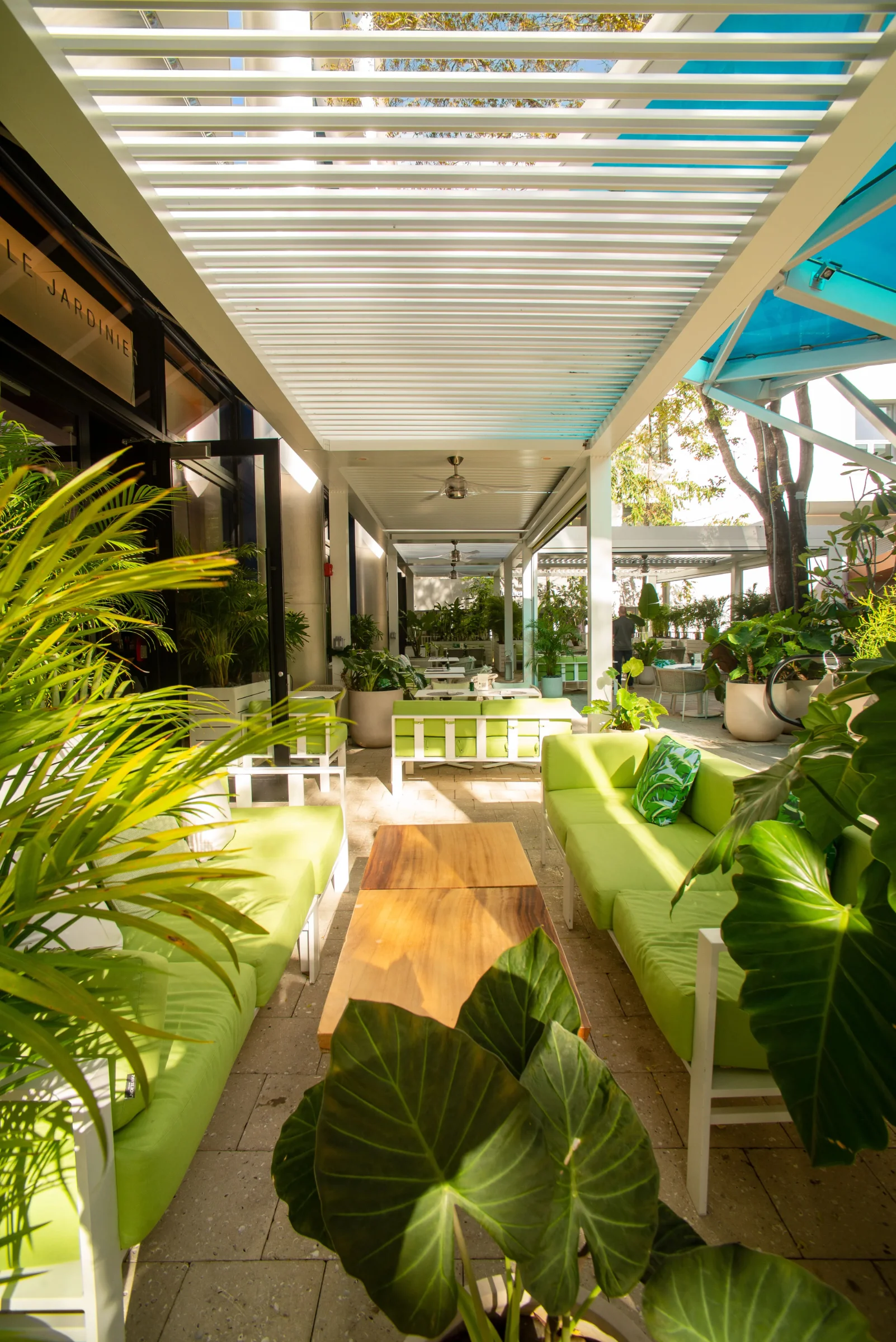 Motorised louvered roof zones over a Miami restaurant terrace with blades rotated partly open