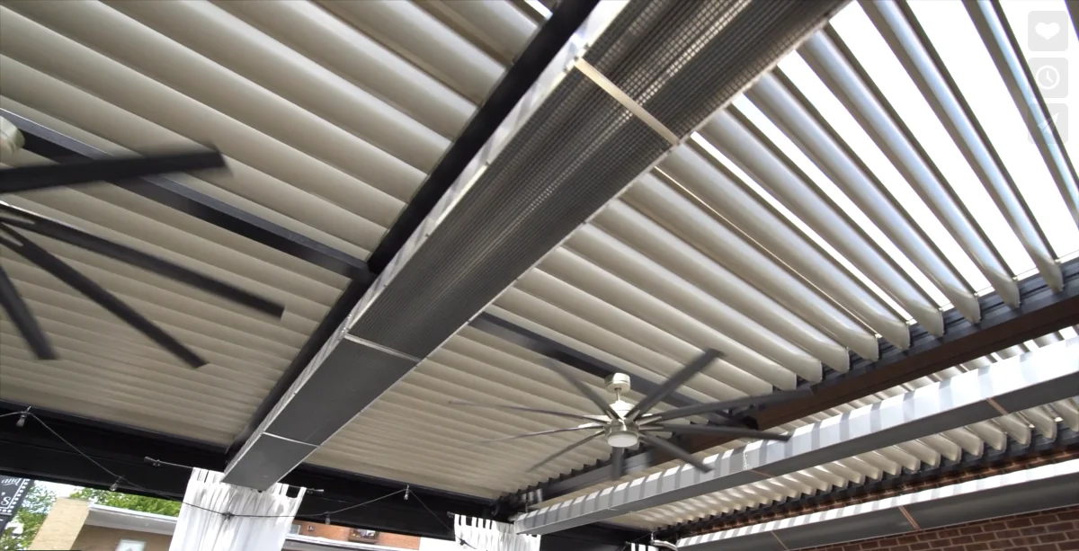 Underside of an aluminum louvered roof with ceiling fan