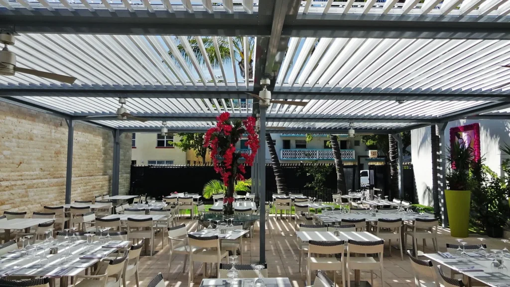 White louvered aluminum roof over a South Beach restaurant terrace with the louvers closed for shade