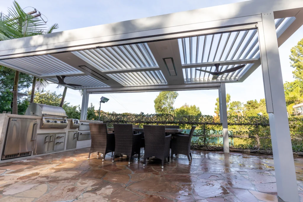 White StruXure louvered pergola over a flagstone patio with outdoor kitchen and pool in Pinecrest FL