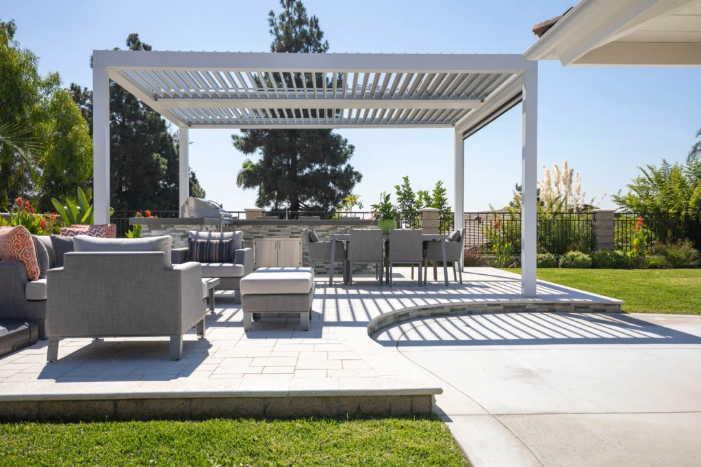 White StruXure louvered pergola with open louvers over a modern Miami patio with sectional seating and outdoor dining