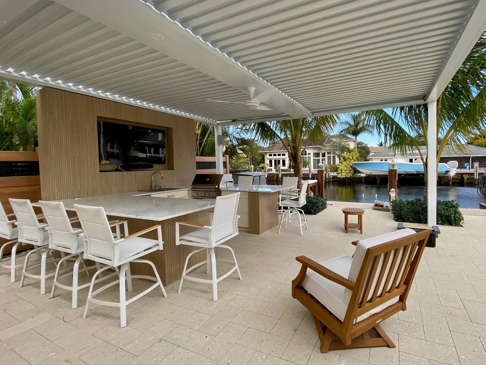 White StruXure motorized pergola with LED lighting over a Miami outdoor kitchen, built by licensed pergola builders in Miami