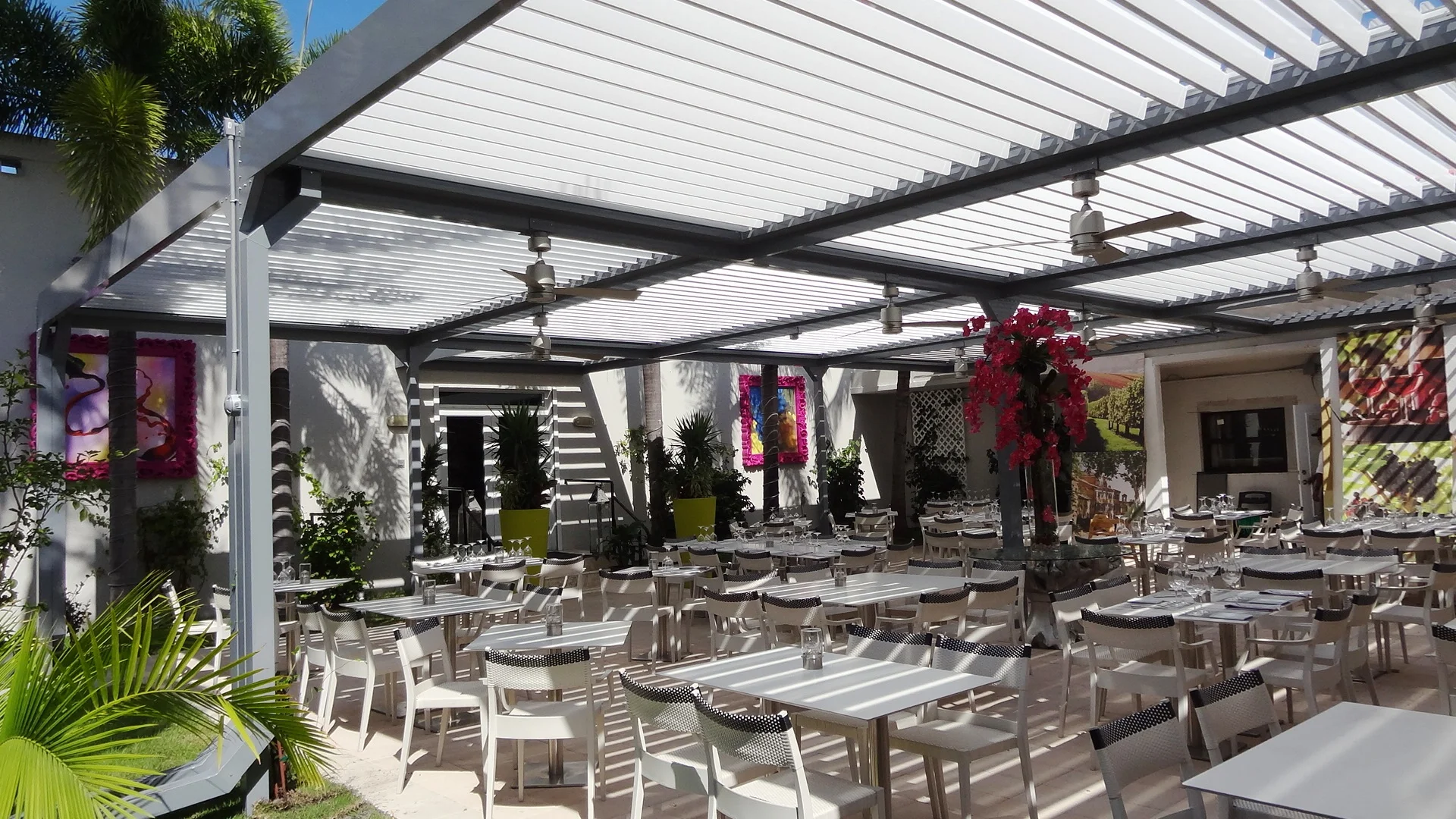 Tiki hut vs pergola comparison: white louvered pergola over a Miami Beach dining patio with the roof open