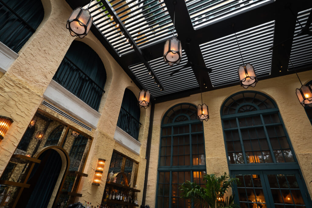 Closed-louver aluminum pergola shedding rain over an outdoor living area in South Florida