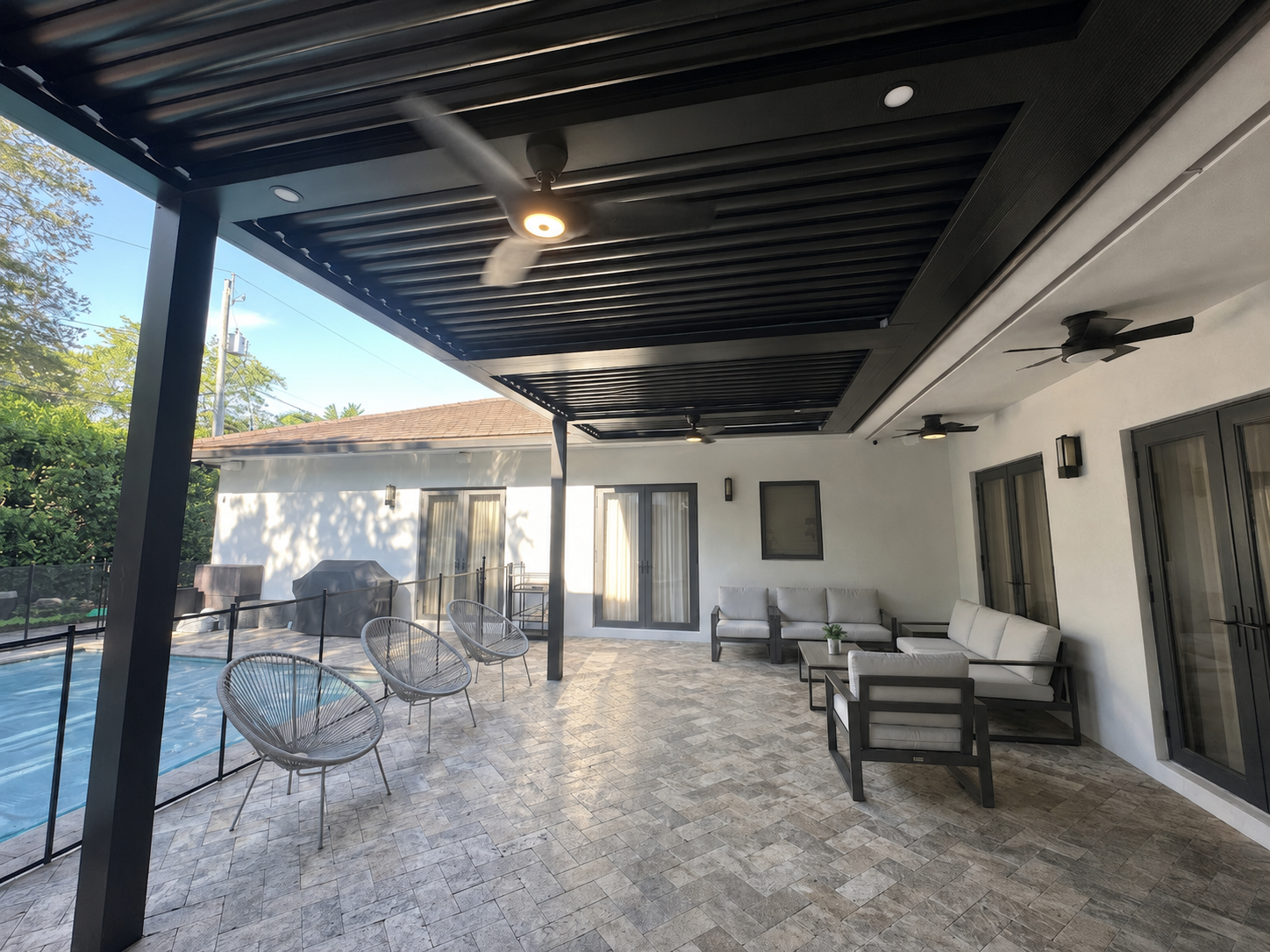 Dark louvred roof over a covered patio with glass railing in South Florida