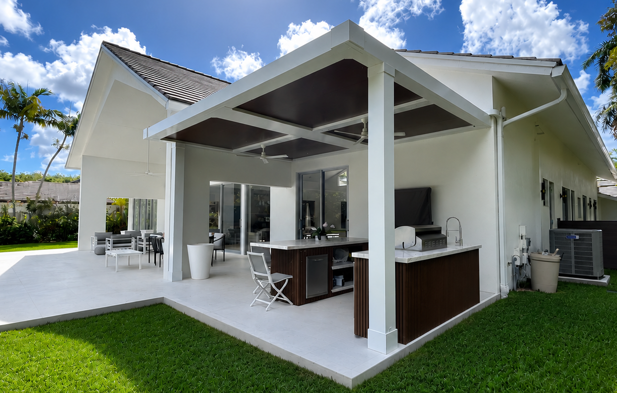White louvered roof over an outdoor kitchen with a built-in grill under a pergola in Florida