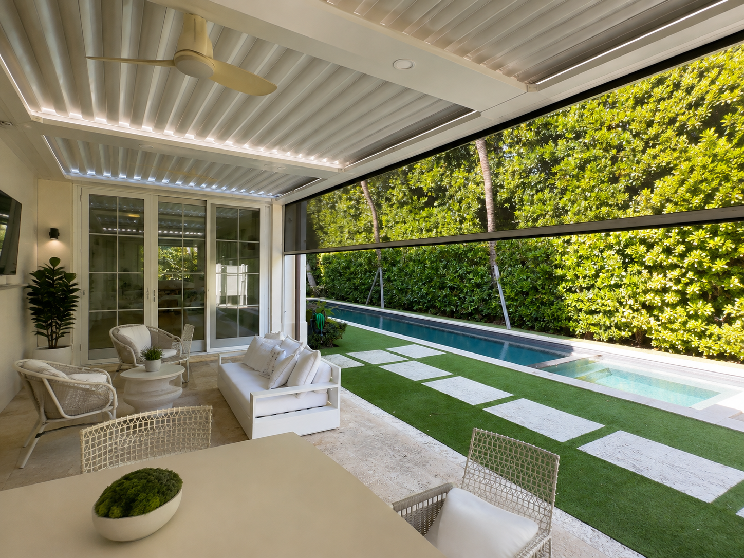 Louvered pergola shading a lounge area beside a lap pool at a modern Florida home
