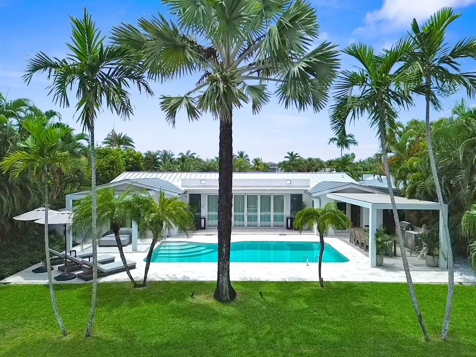 Waterfront South Florida estate with a white pergola and pool exposed to coastal salt air